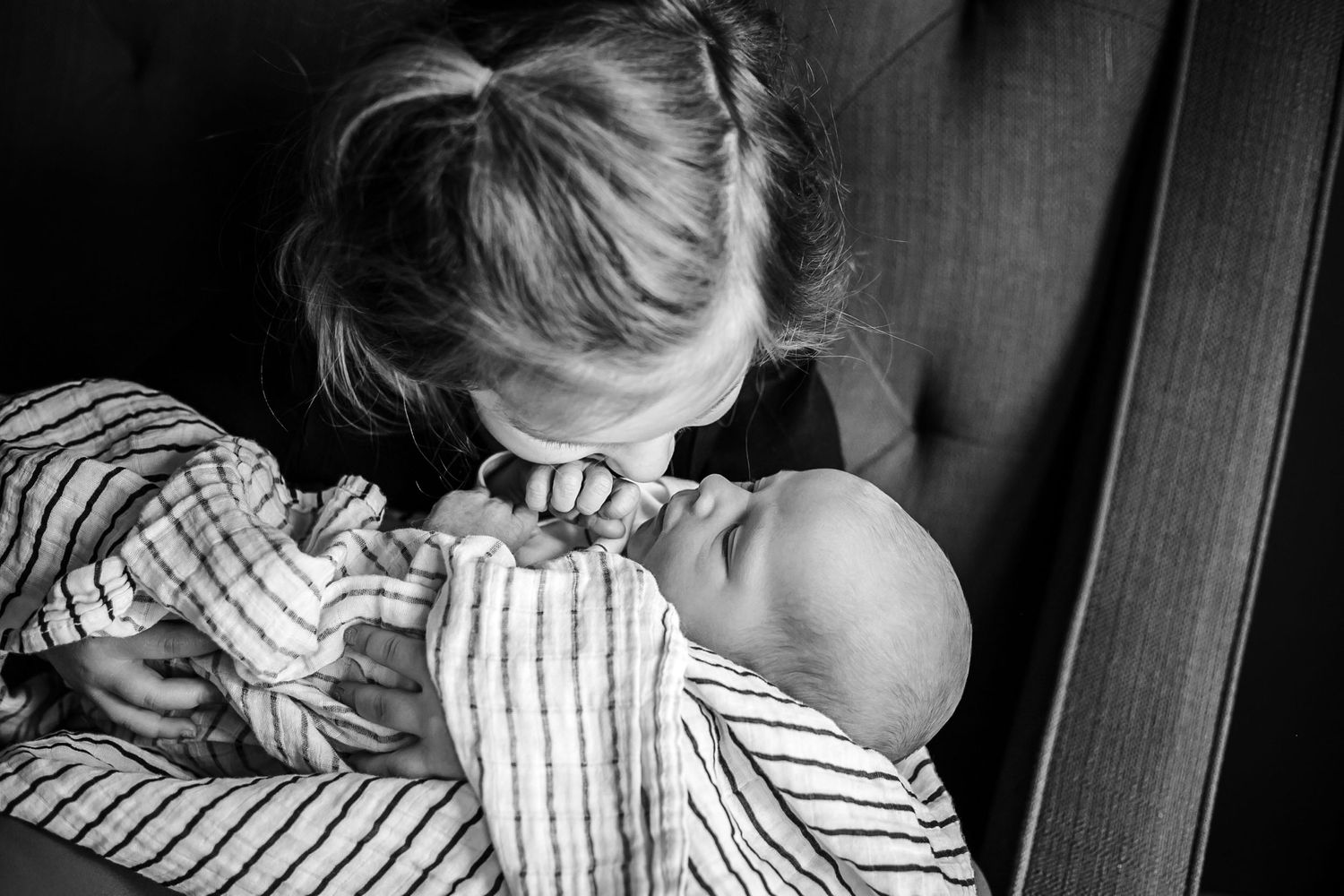 Big sister snuggling her new baby brother during their in-home newborn session in Sioux City, IA.