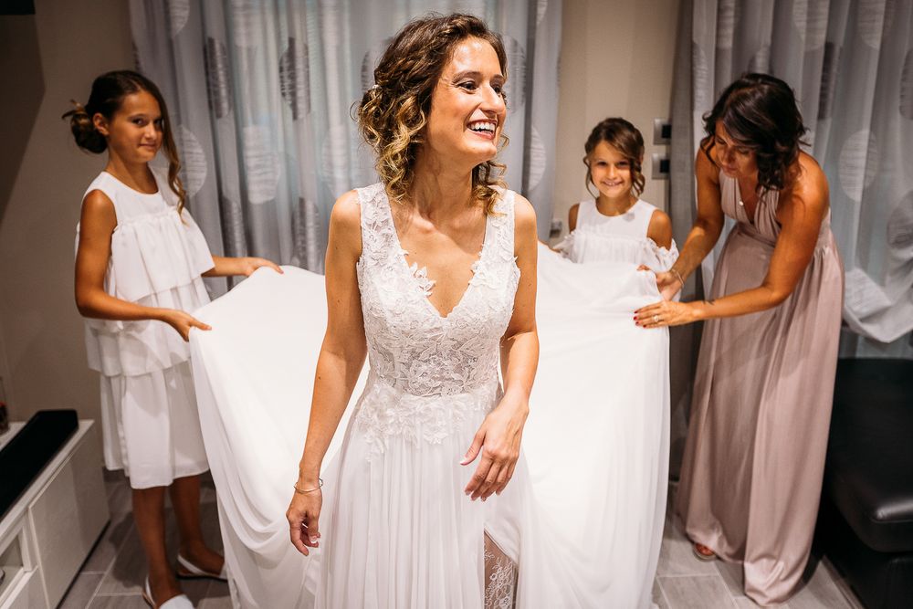 Wedding preparations show attendants in white dresses helping with final touches.