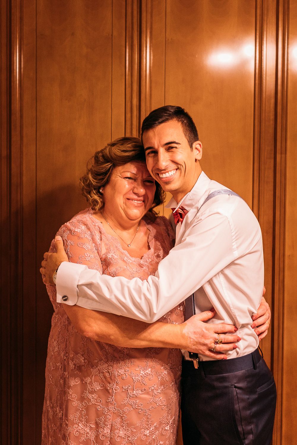 Emotional moment captured during wedding preparations in warm lighting.
