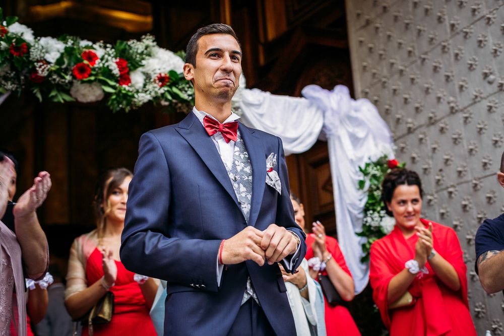 A formal celebration outside with attendees in navy and red attire.