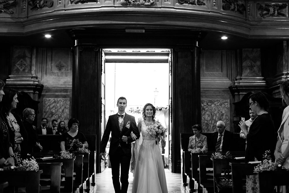 A dramatic black and white photo showing a processional in an ornate church aisle.