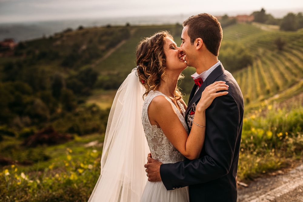 Romantic sunset portrait of newlyweds embracing in a vineyard setting.