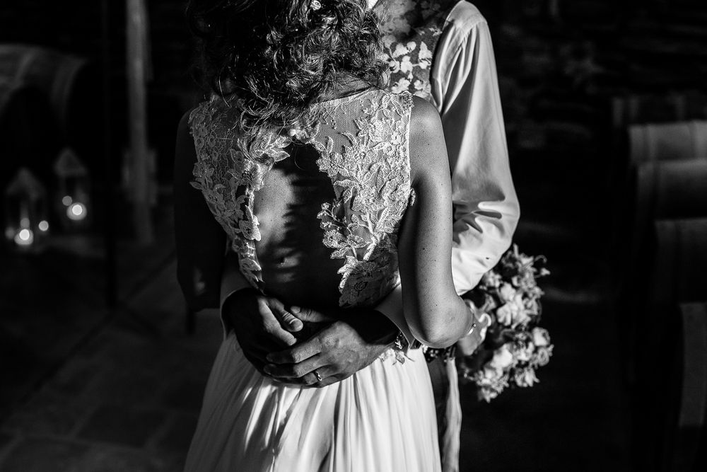 Artistic black and white wedding portrait with lace dress details.