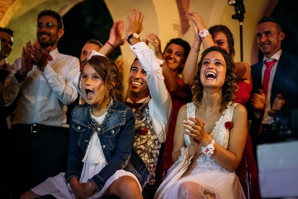 Wedding guests cheering and celebrating with joyful expressions during the reception.