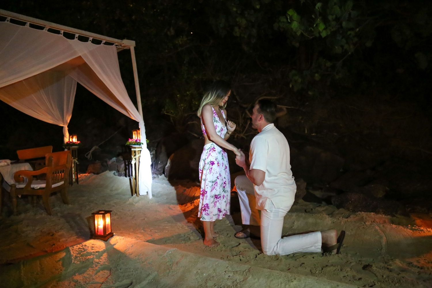 man proposes to woman on beach in Thailand. He gets down on one knee.