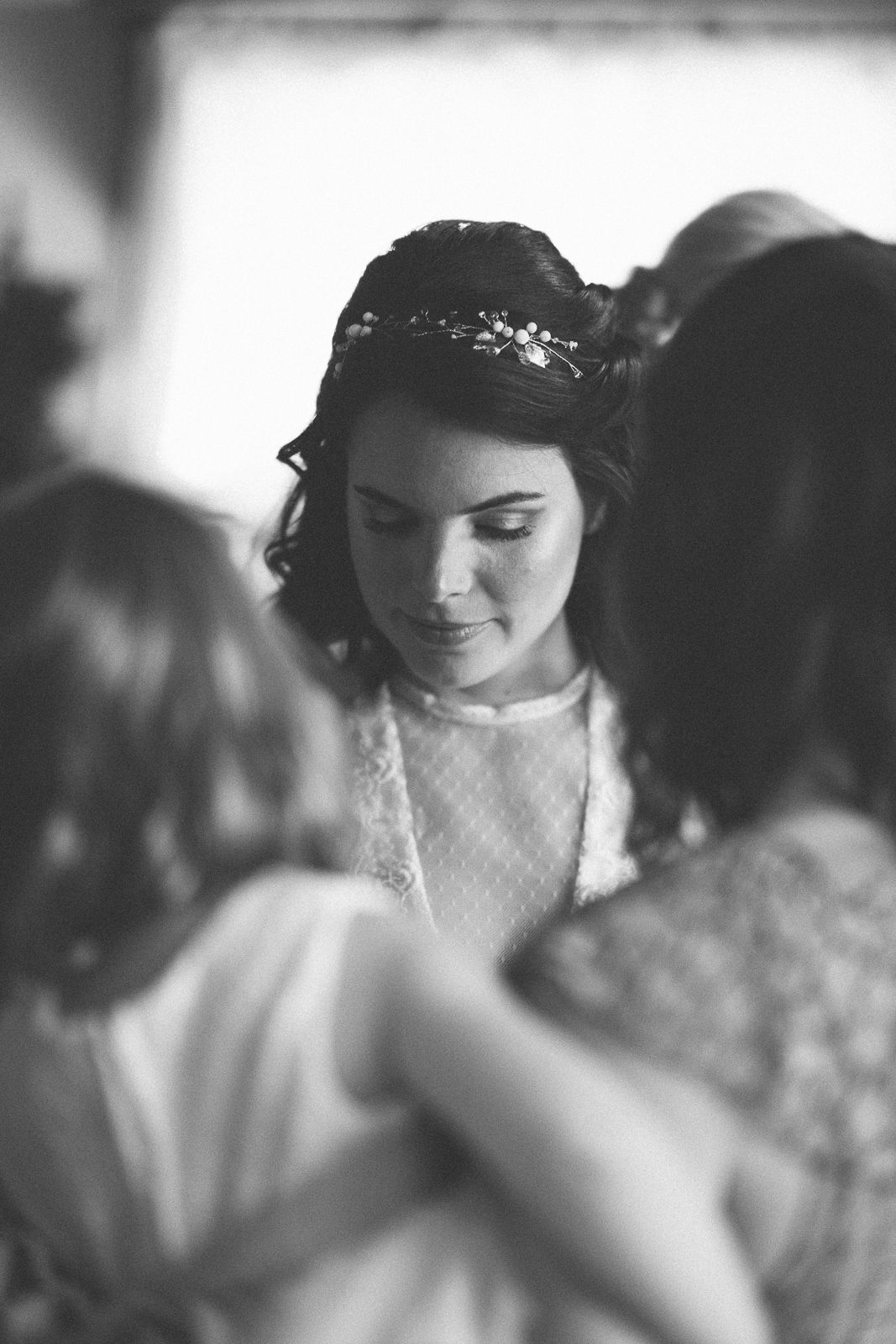 Black and white portrait of bride wearing delicate lace dress and headpiece.