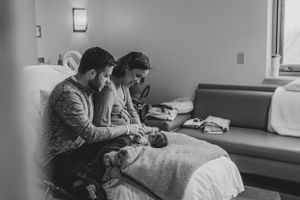 Family bonding moment captured in soft, natural light in a bedroom setting.