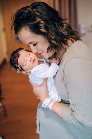 Emotional moments between parent and newborn captured in warm lighting.