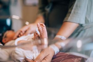 Gentle hands care for a newborn baby in a hospital setting.