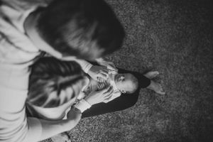 Overhead view of someone playing with stuffed bunny toy on carpet.