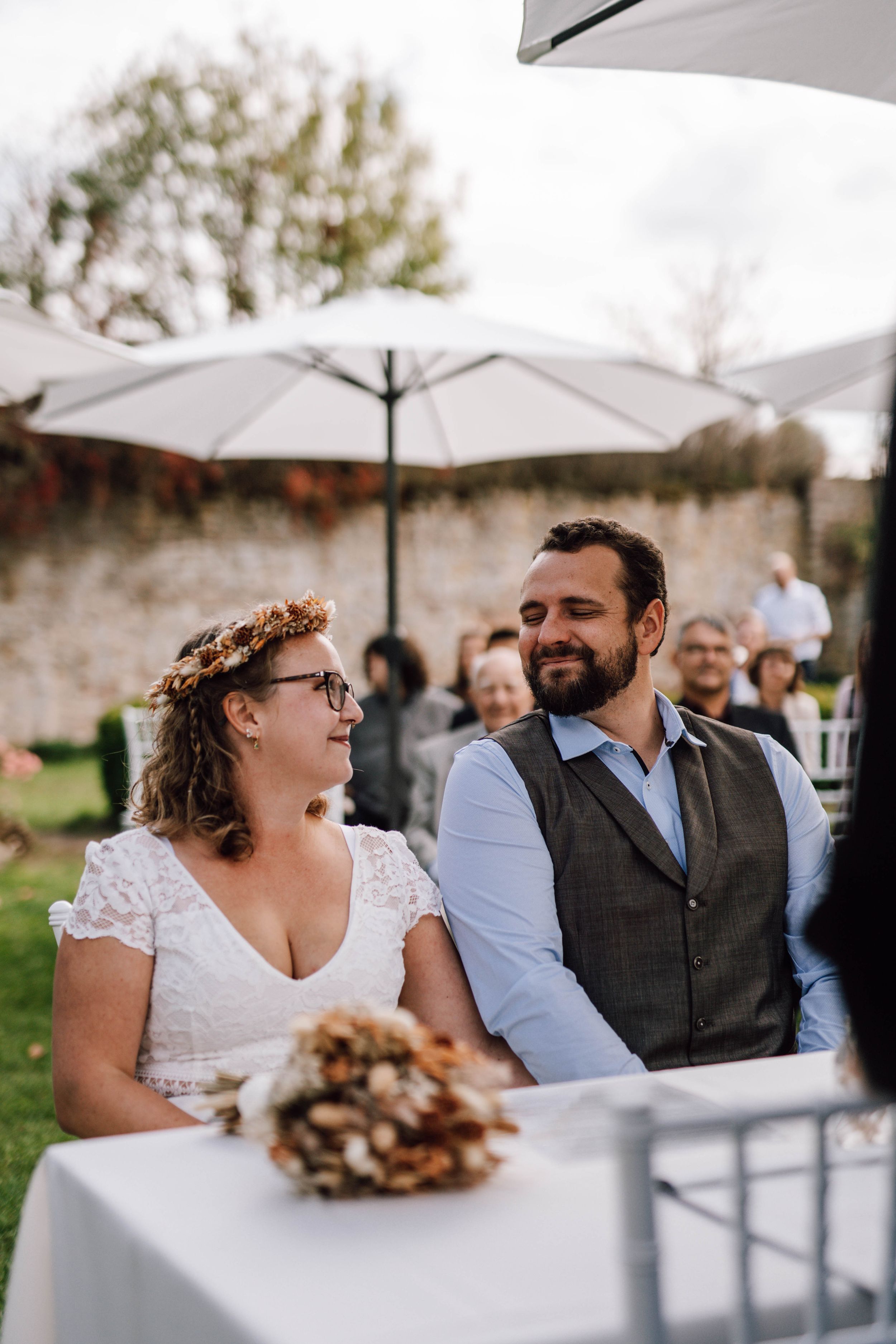 Joyful wedding ceremony moment with couple laughing at outdoor venue.