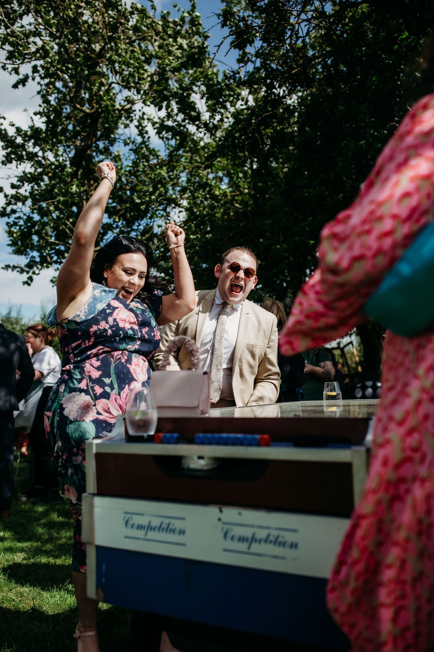 Guests celebrate enthusiastically at an outdoor event with a Temptation ice cream cart.