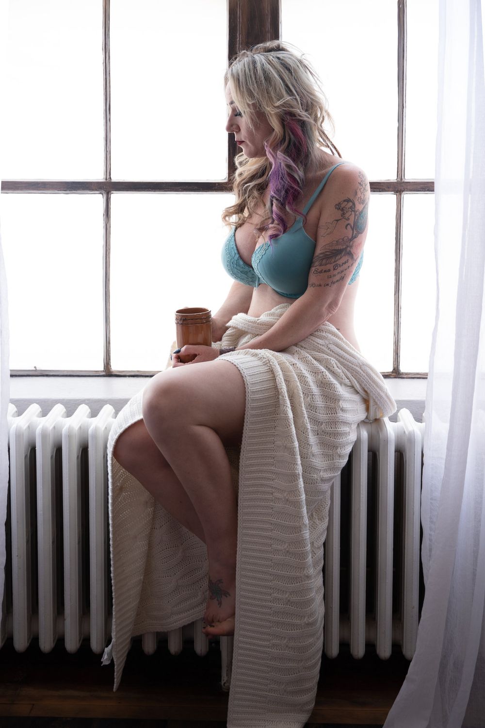 Soft natural window light portrait with teal bralette and draped white fabric.