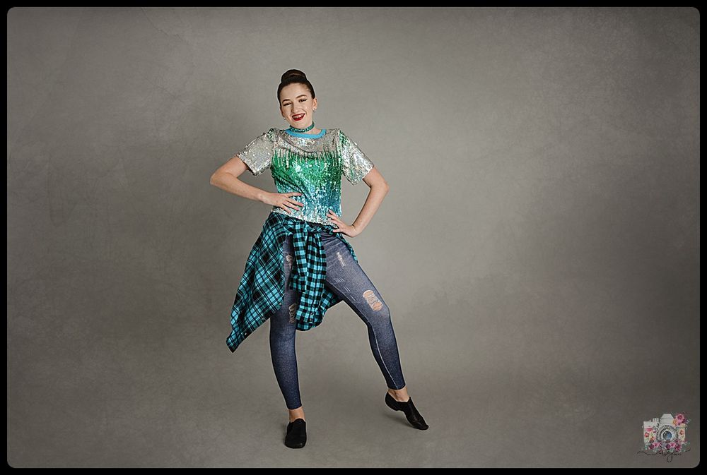 Dancer in casual outfit with plaid shirt performs contemporary dance move.