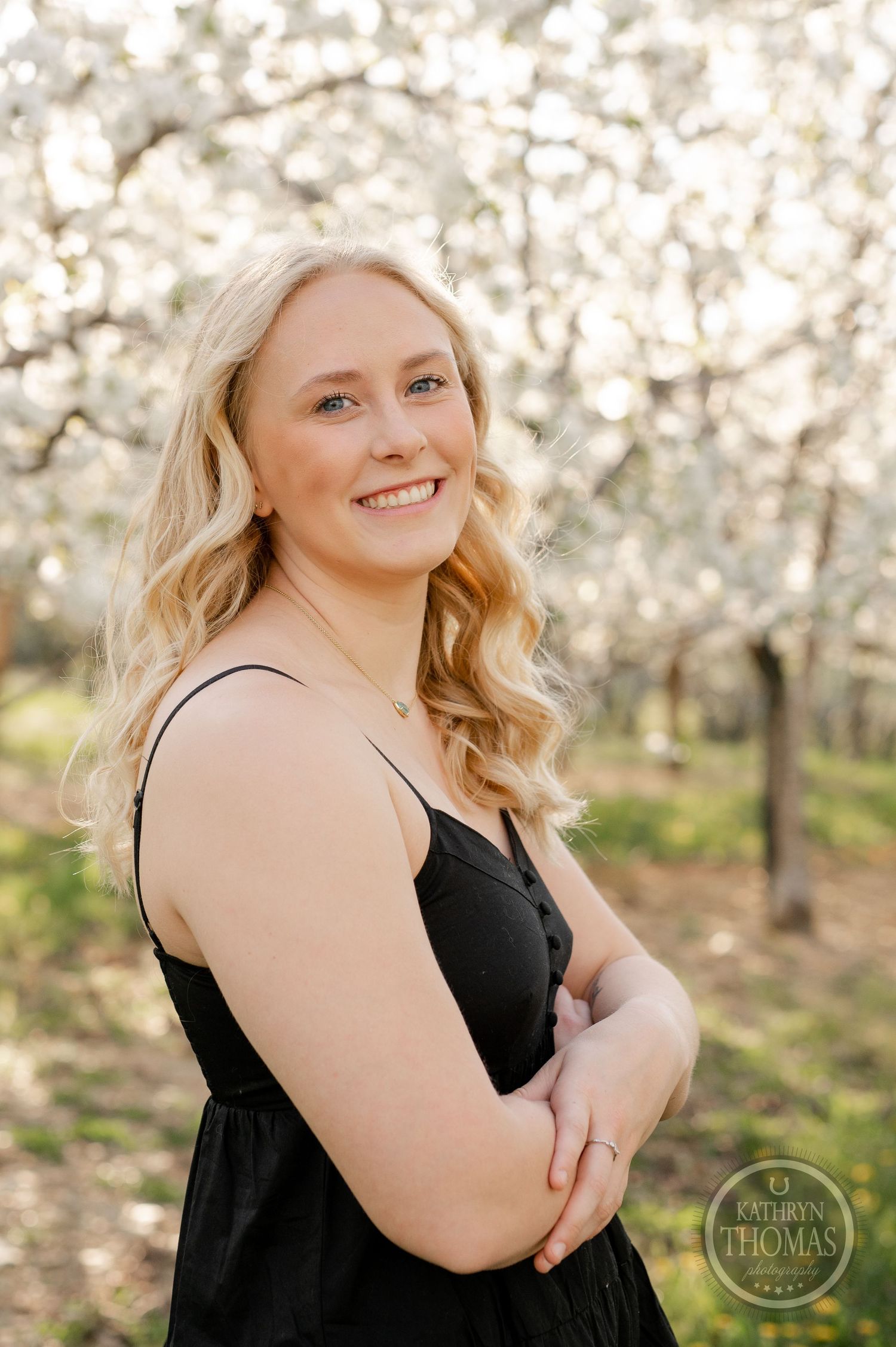 Spring portrait session showcasing blooming orchard trees in warm afternoon light.