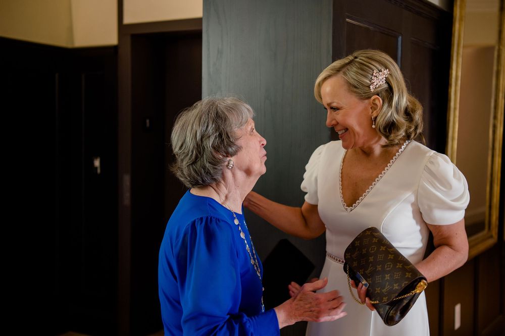 Joyful interaction between two people during special celebration moment indoors.Commodore Perry Estate Wedding