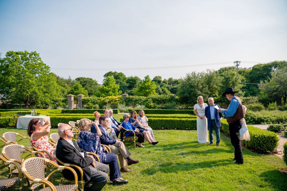 Garden wedding ceremony with guests seated on white chairs surrounded by manicured hedges.Commodore Perry Estate Wedding