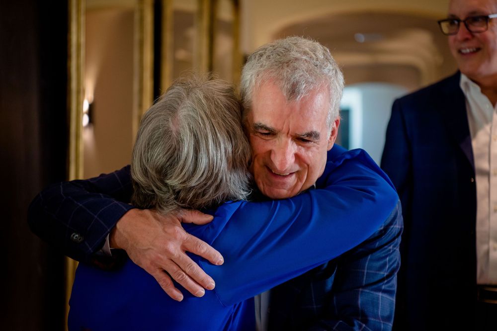 Emotional embrace shared between two people during indoor celebration.Commodore Perry Estate Wedding