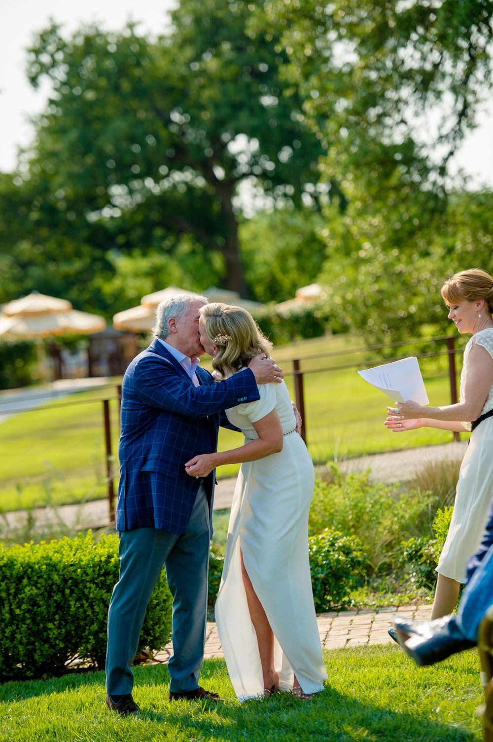 Tender moment captured during garden wedding ceremony with officiant present.Commodore Perry Estate Wedding