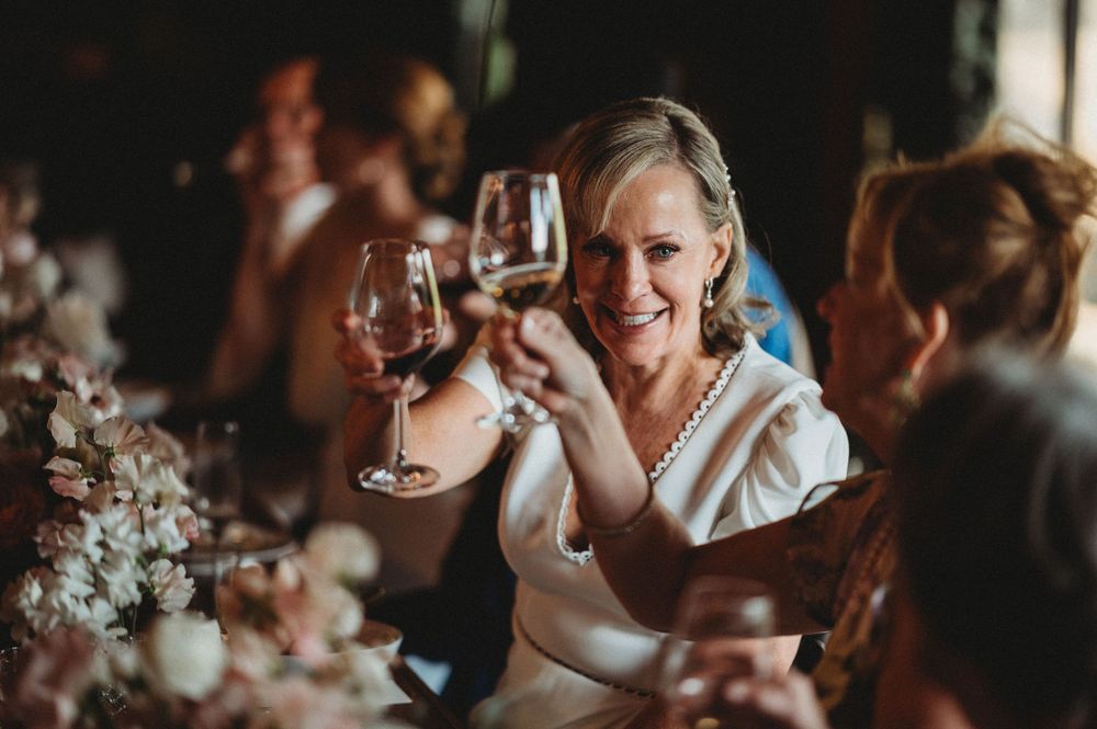 A celebratory toast with wine glasses during an intimate dinner gathering.Commodore Perry Estate Wedding