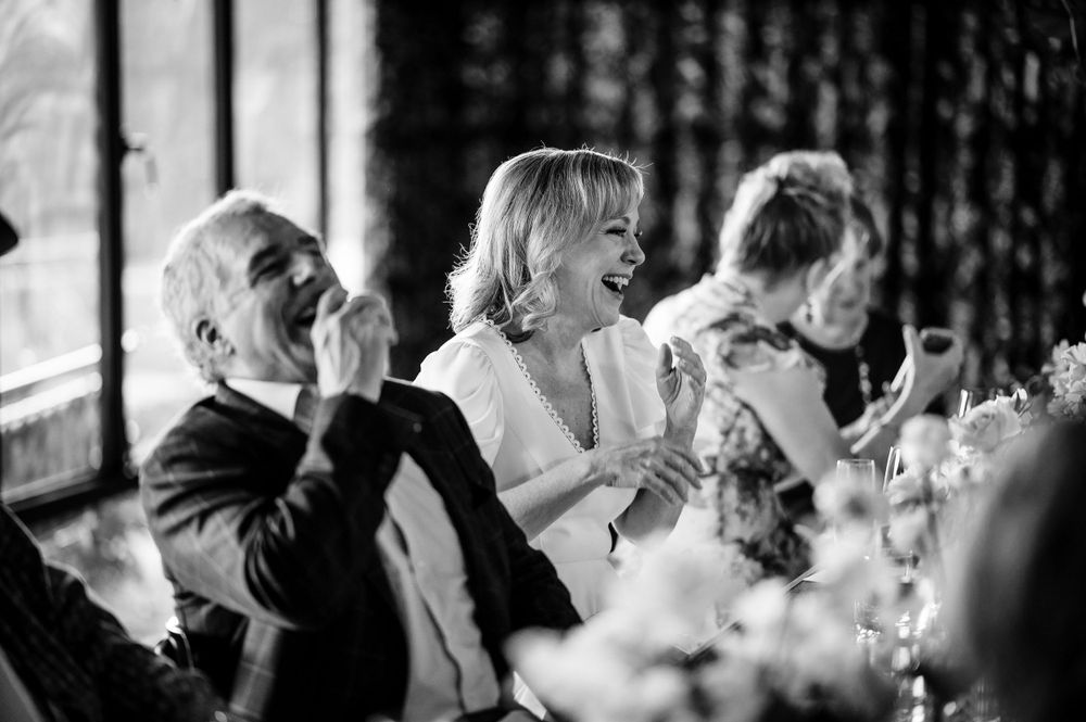 Joyful laughter shared among guests during an indoor celebration.Commodore Perry Estate Wedding