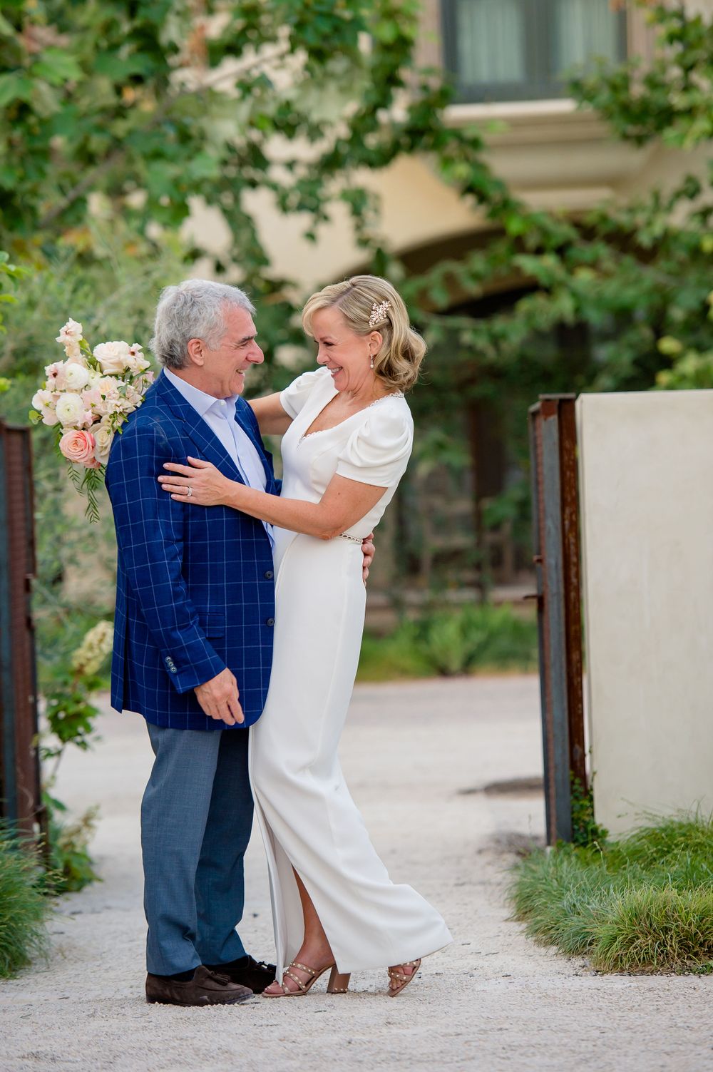 A couple shares a tender moment on a garden path wearing formal attire.Commodore Perry Estate Wedding