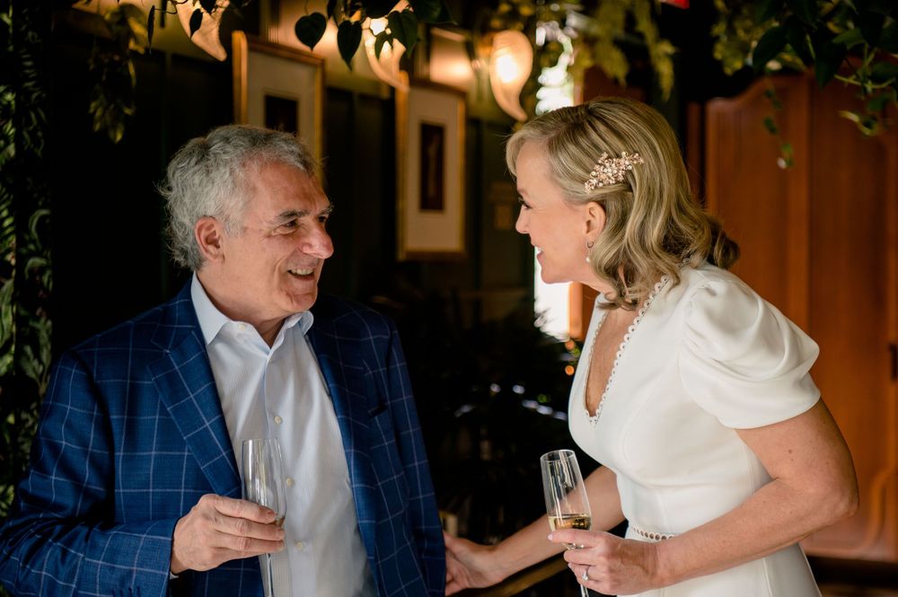 Candid moment shows joyful laughter during an outdoor evening reception.Commodore Perry Estate Wedding