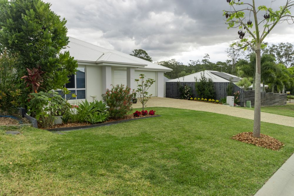 Modern single-story home with neat lawn and young trees in the front garden.