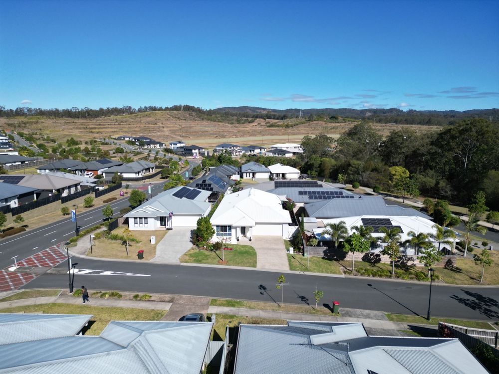 Elevated view of residential houses and streets in a suburban development against blue sky.