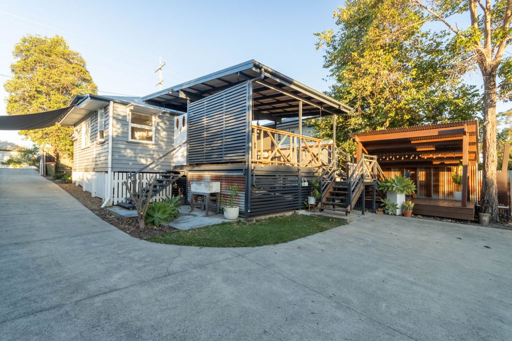 Modern blue-gray house exterior with wooden deck and contemporary architectural design.