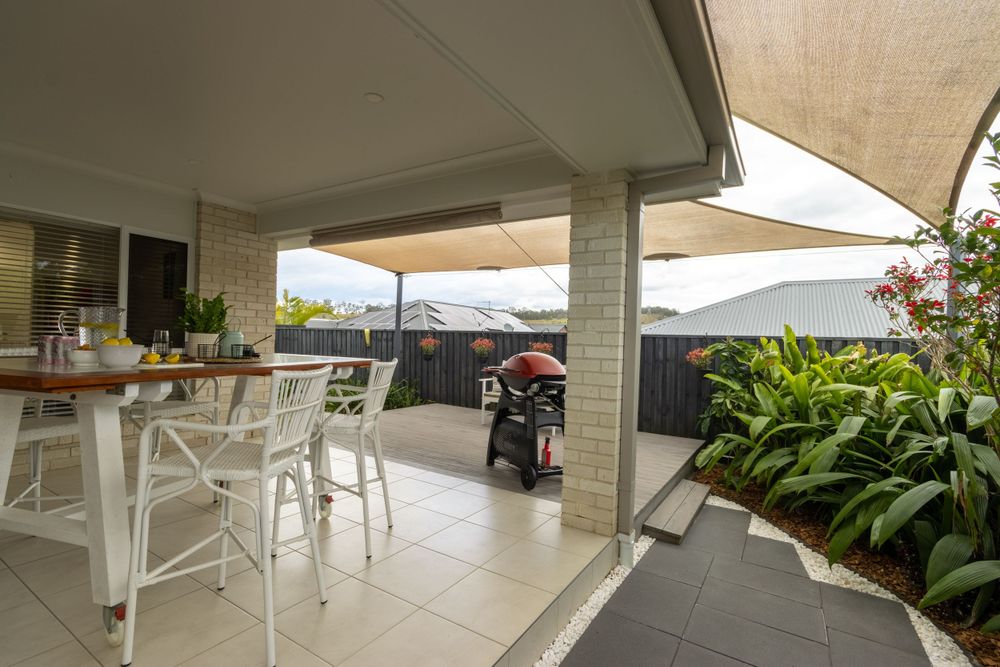 Spacious covered patio area with white bar seating and tropical garden views.