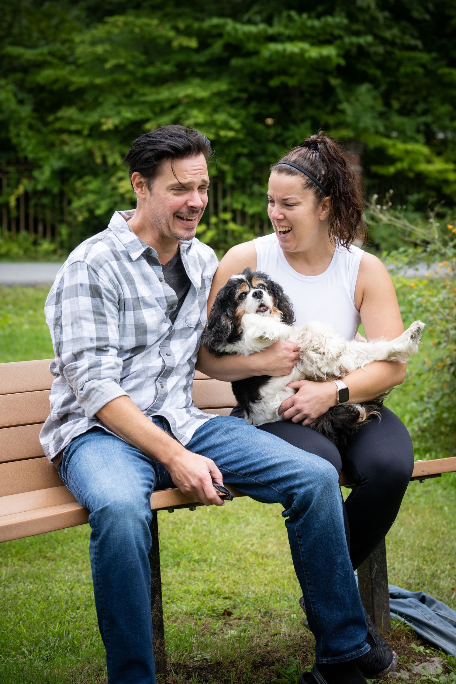 man and woman laughing with dog