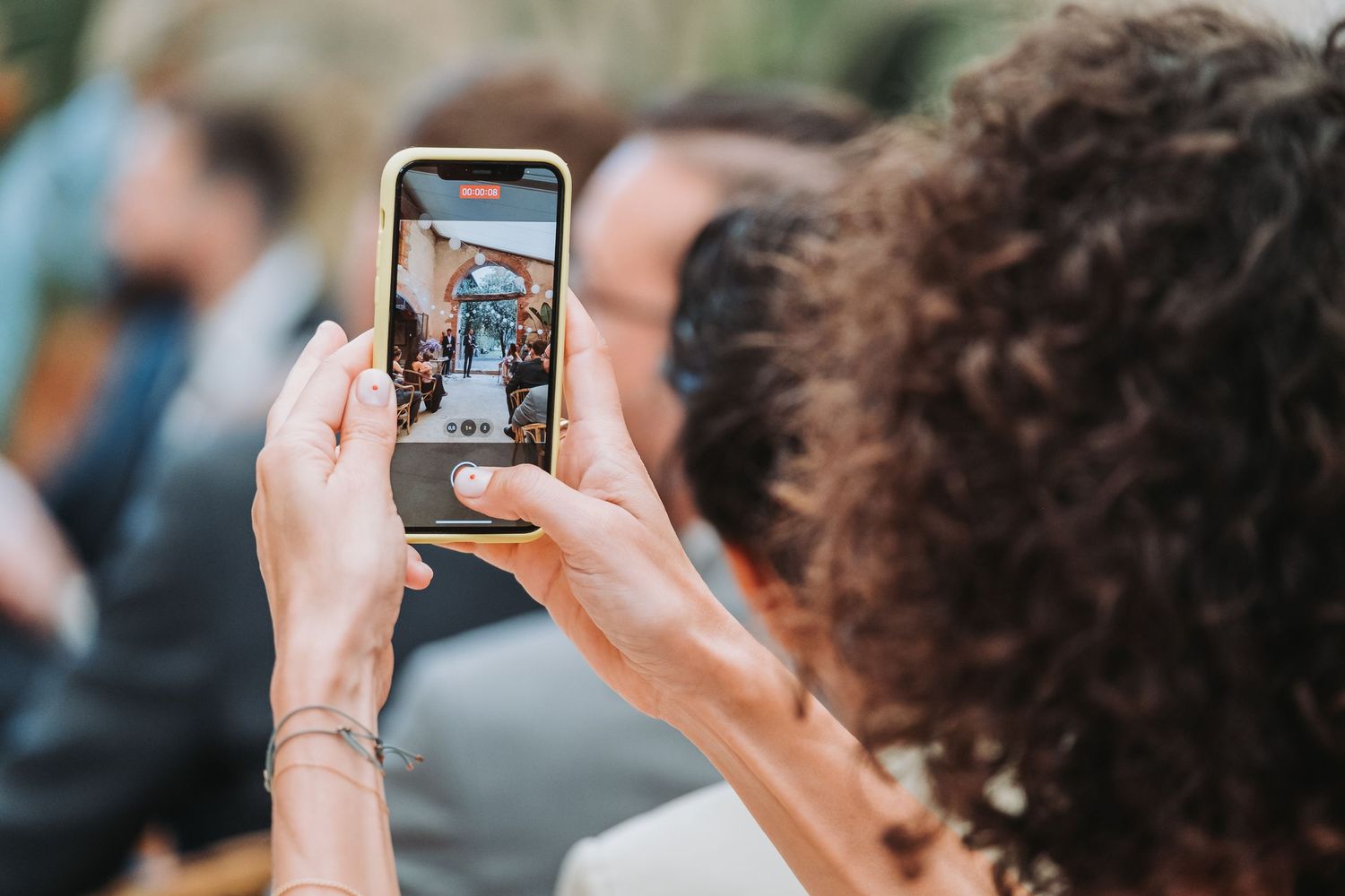 People taking photos with smartphones at an outdoor event.