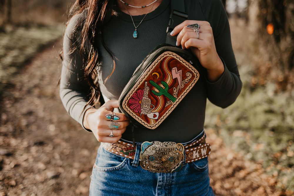 Detail shot of western-style belt buckle and decorative container against autumn background.