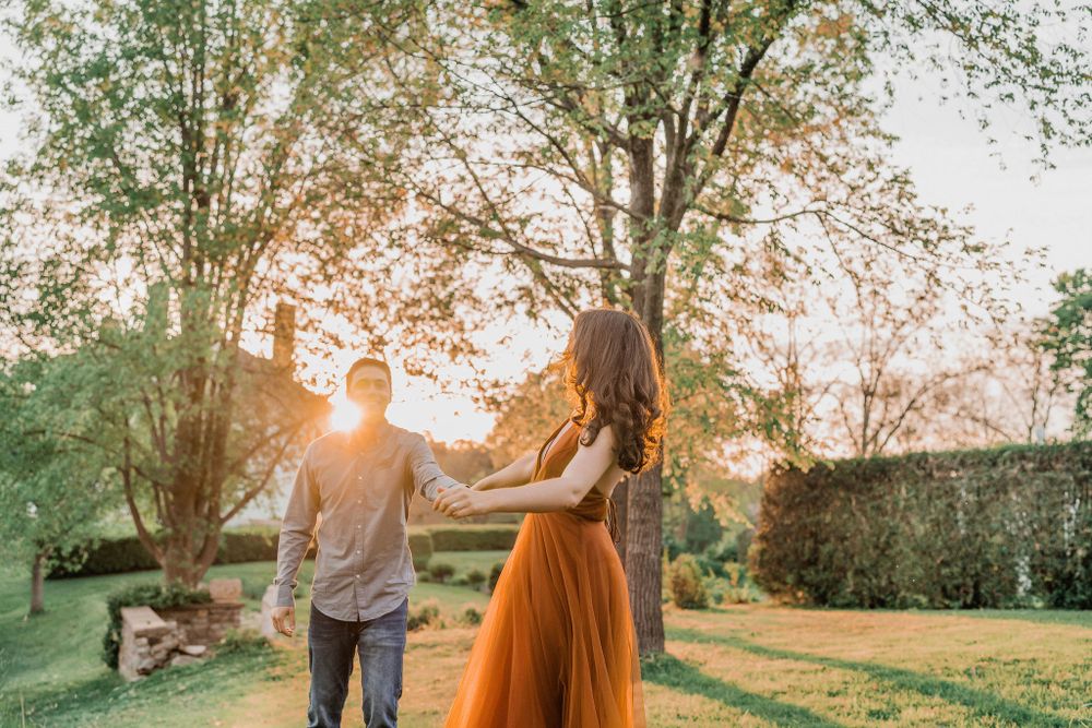 woman looking back at man while running through Hamilton House gardens in Maine
