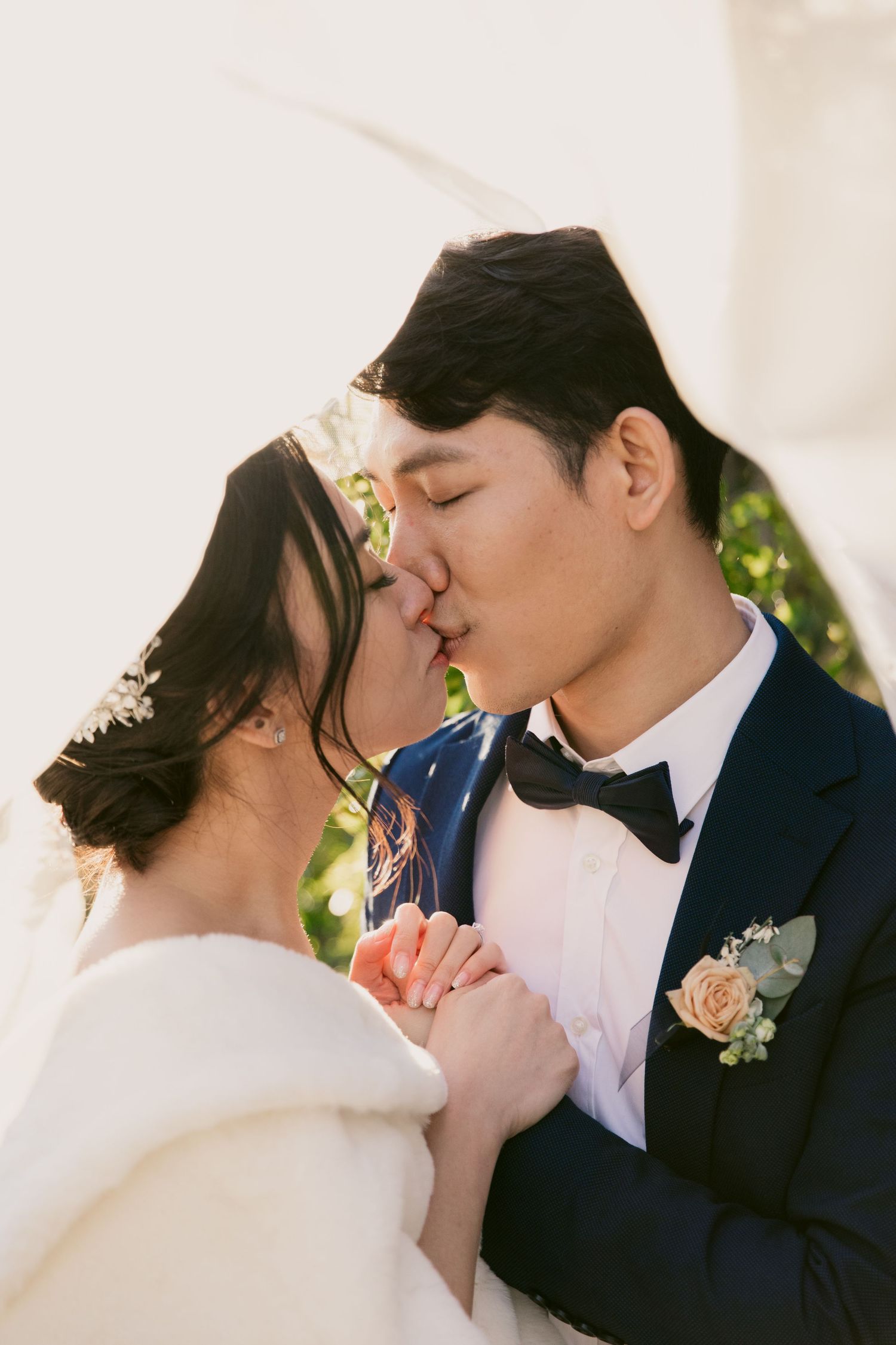 Romantic wedding portrait of a couple sharing an intimate moment outdoors.