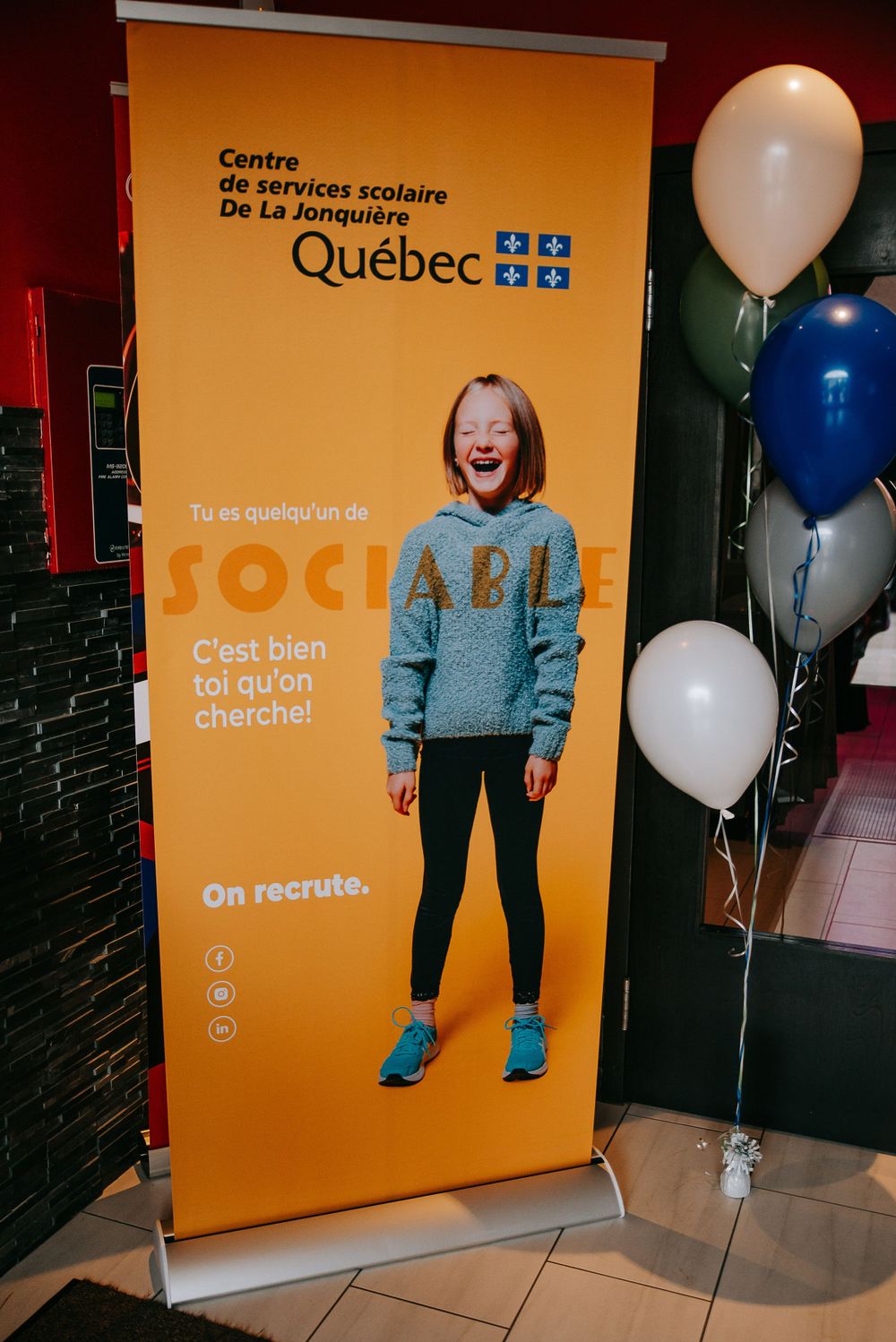 Quebec school services recruitment banner with balloons displayed at an event.