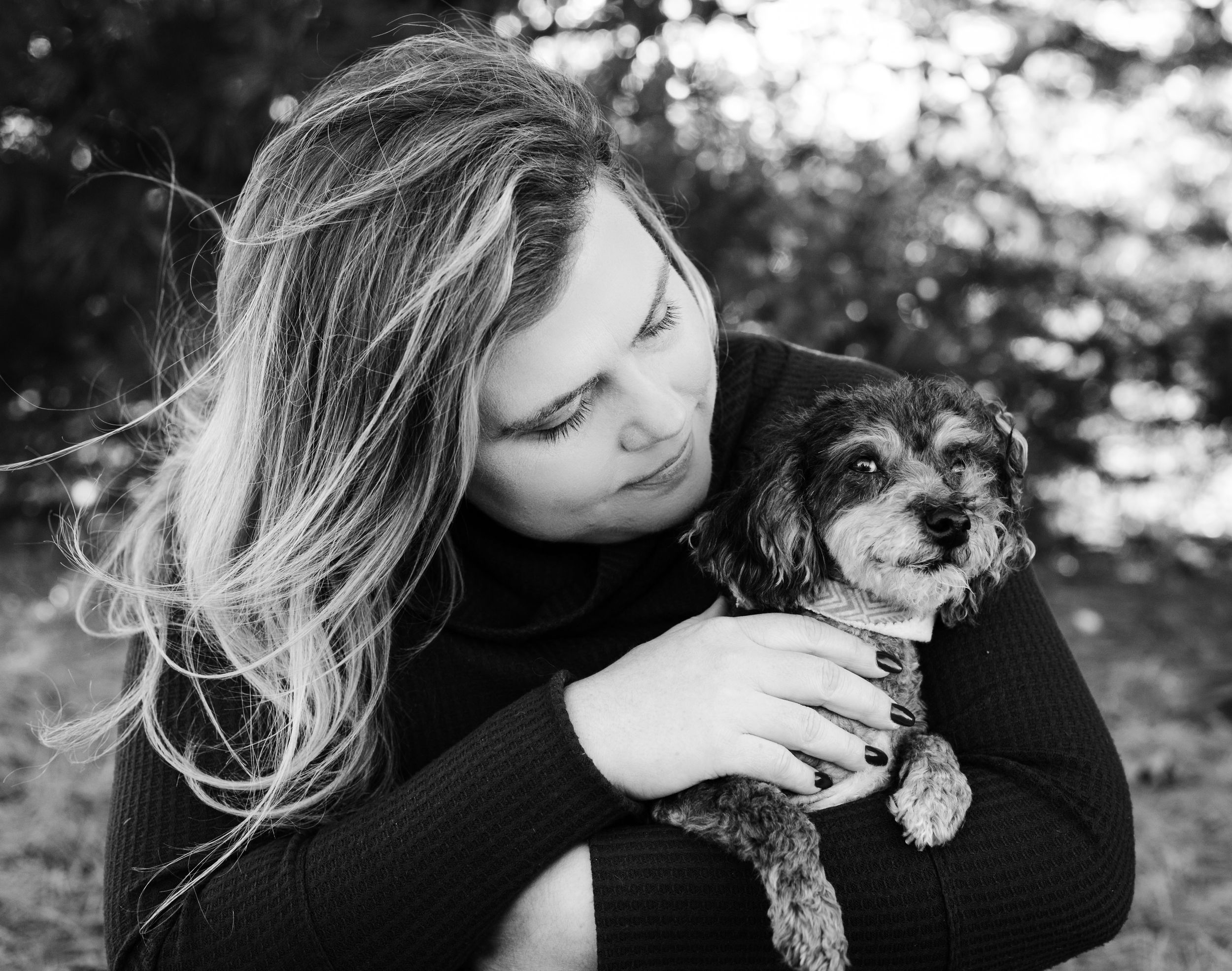 pet owner sincerely looking down at her sick poodle