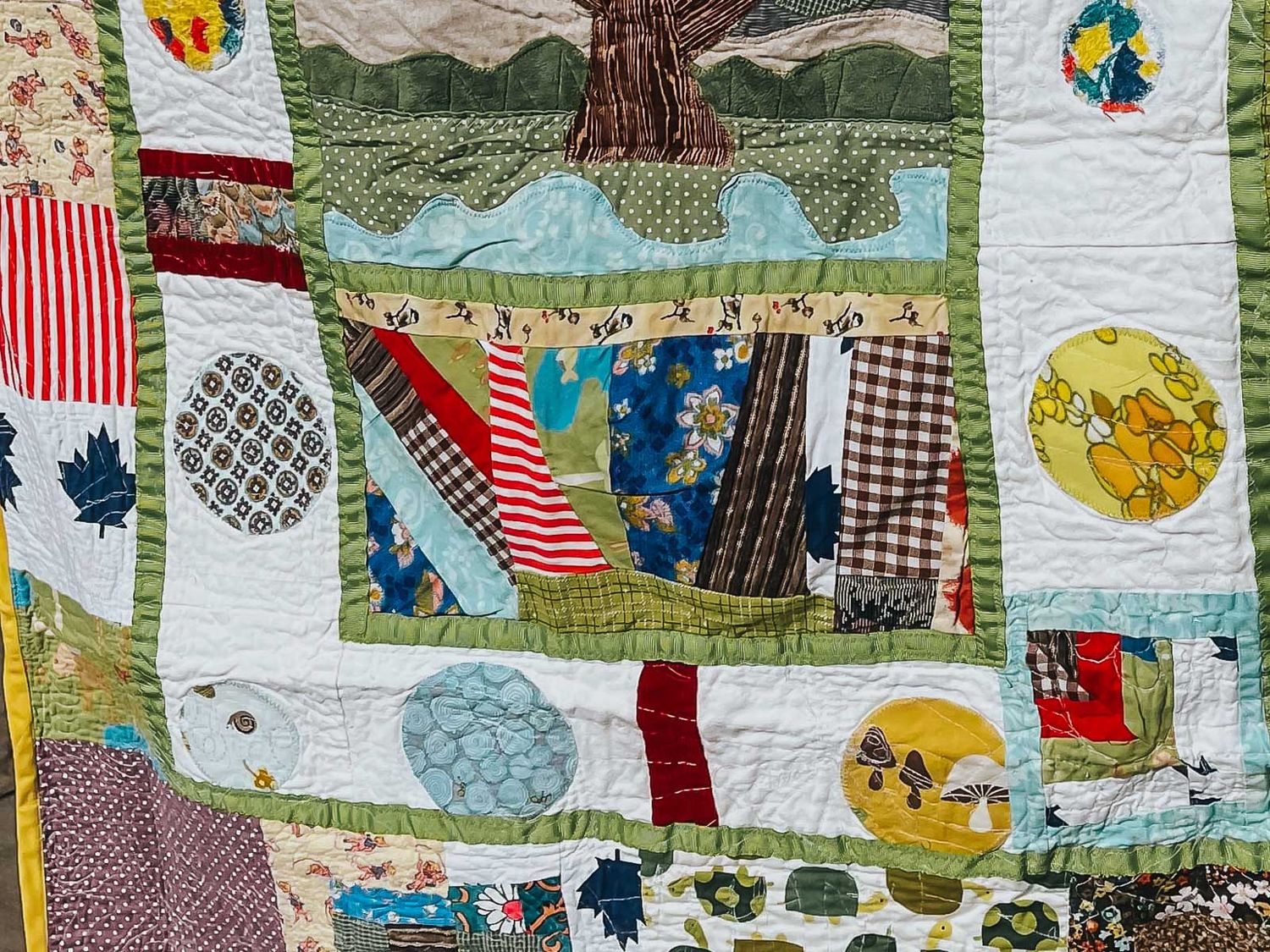 Love patchwork quilt with a white sashing and circles of different fabrics.