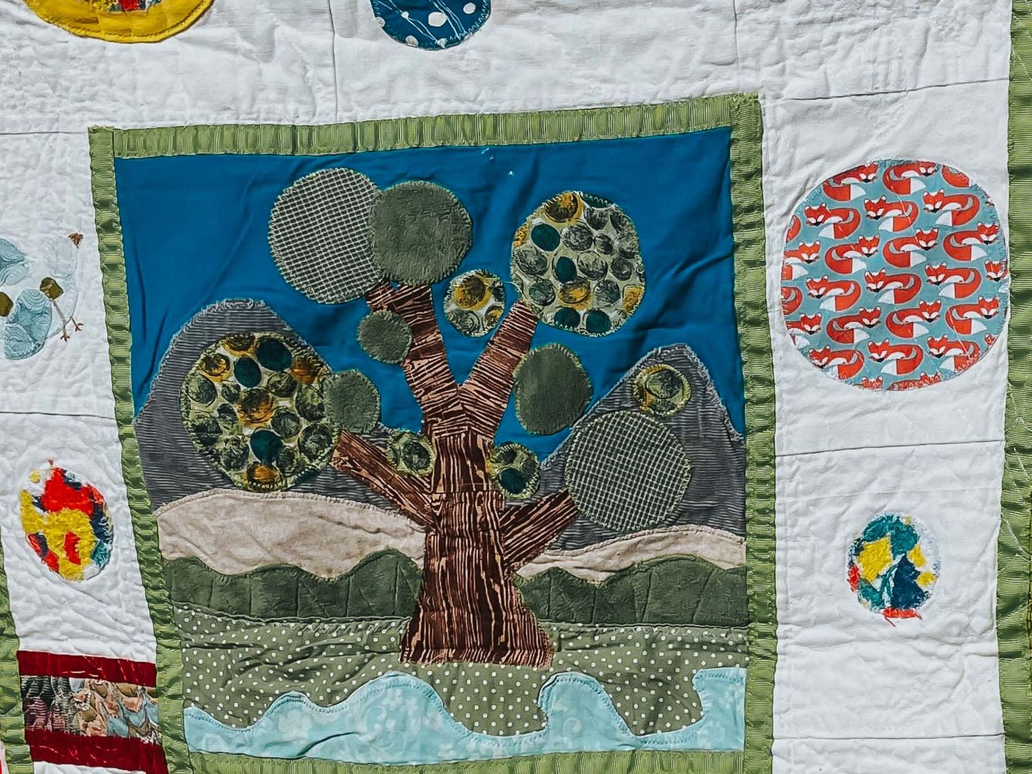 Quilted tree with circles for the leaves section and a trunk made with wood grain fabric.