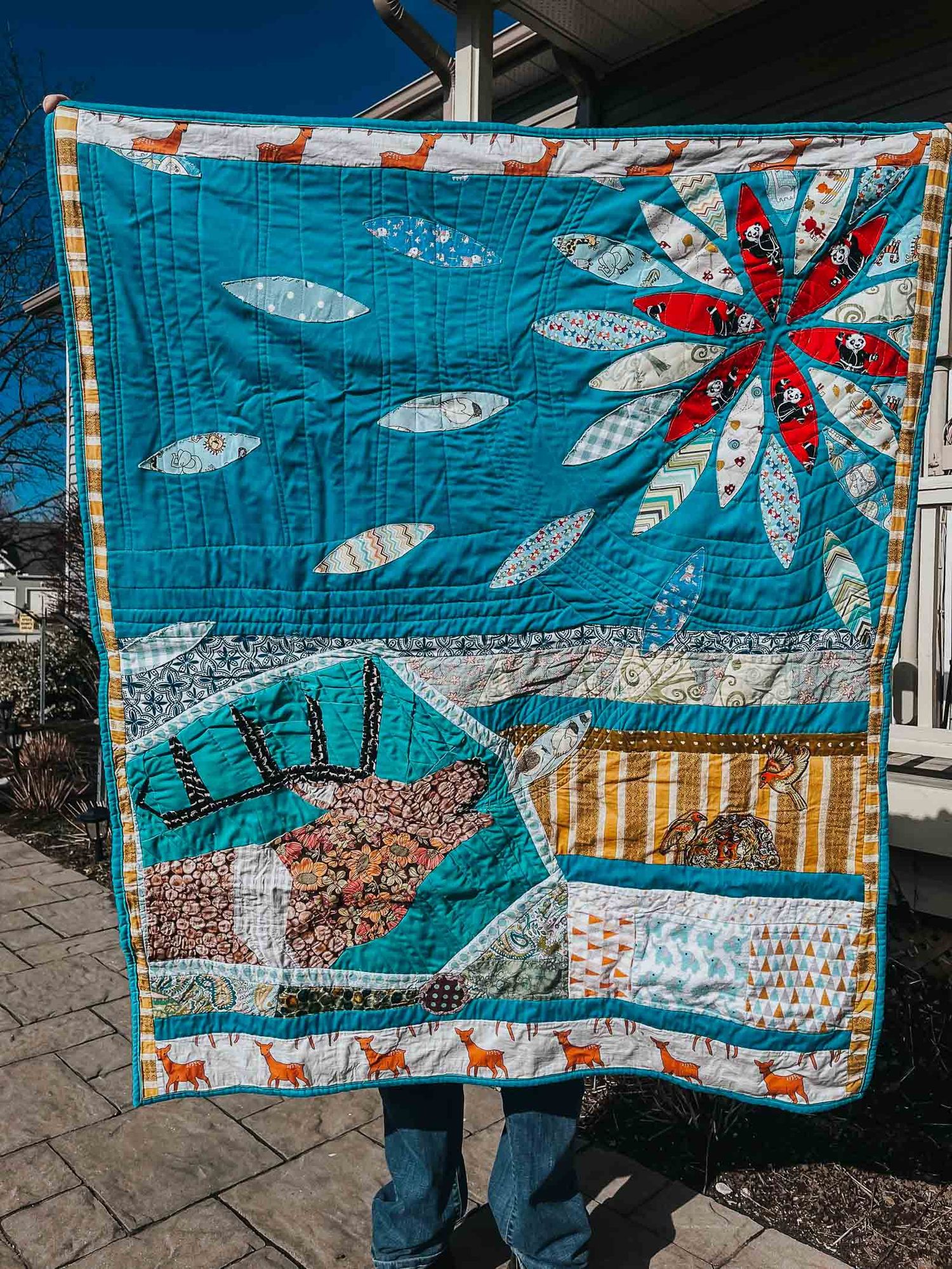 This Splendid Chaos Love quilt of an elk bugling out petal that make a flower in the sky.