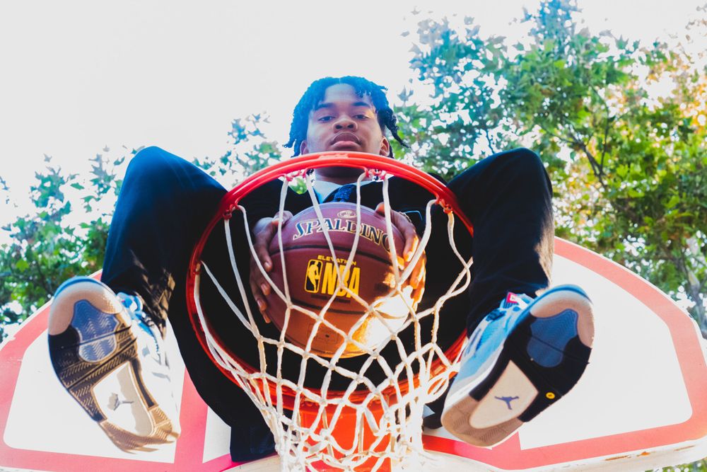 Low angle view looking up at basketball hoop and net against blue sky.