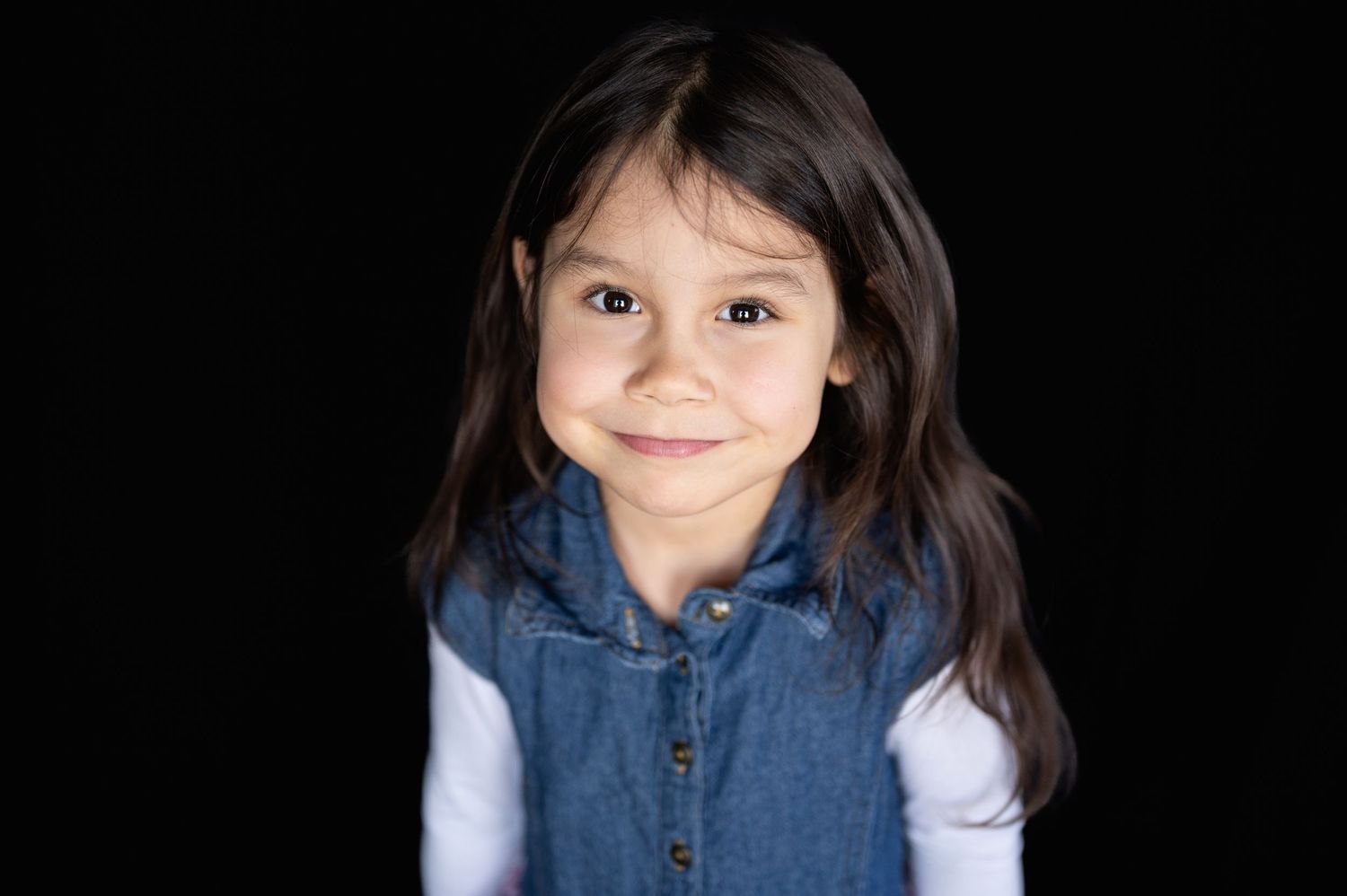 a young girl with brown hair smiles for a portrait