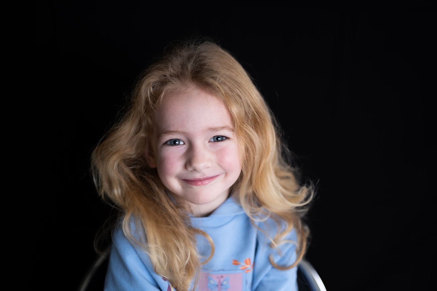 a blonde girl smiles for a fine art portrait