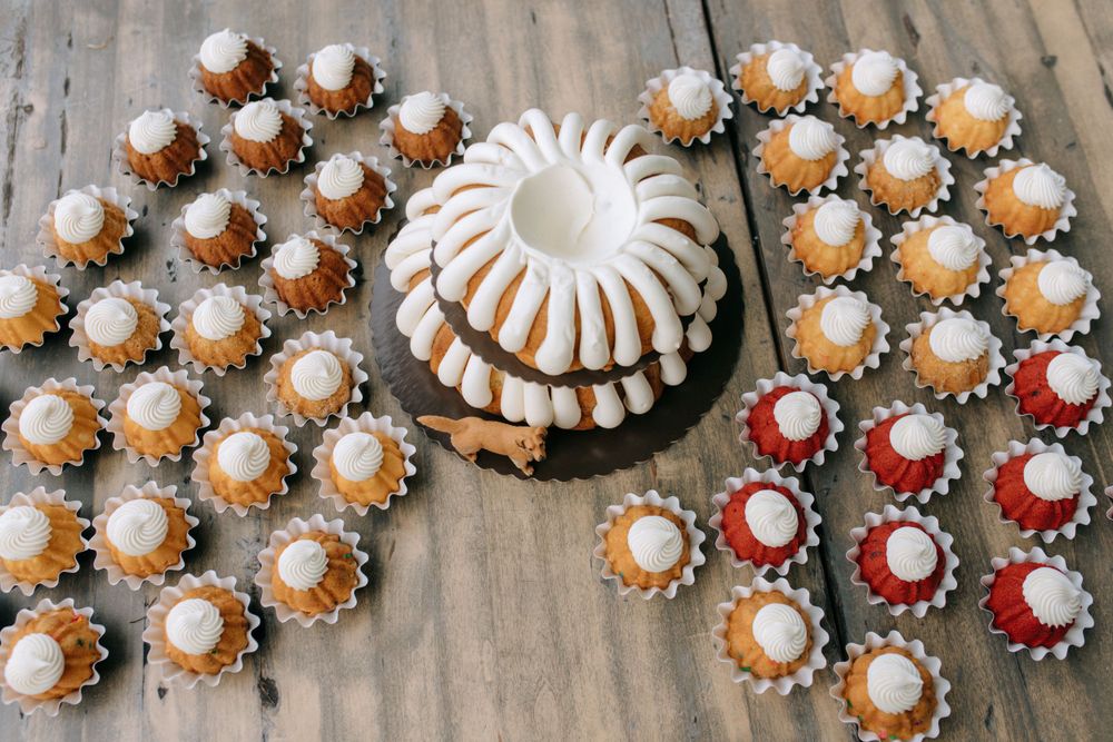 Arrangement of mini bundt cakes with white frosting dots displayed in circular pattern.