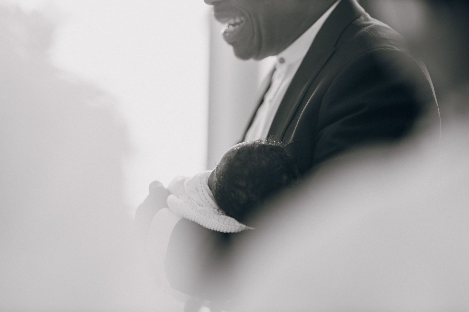 A close-up artistic black and white profile shot of someone in formal attire.
