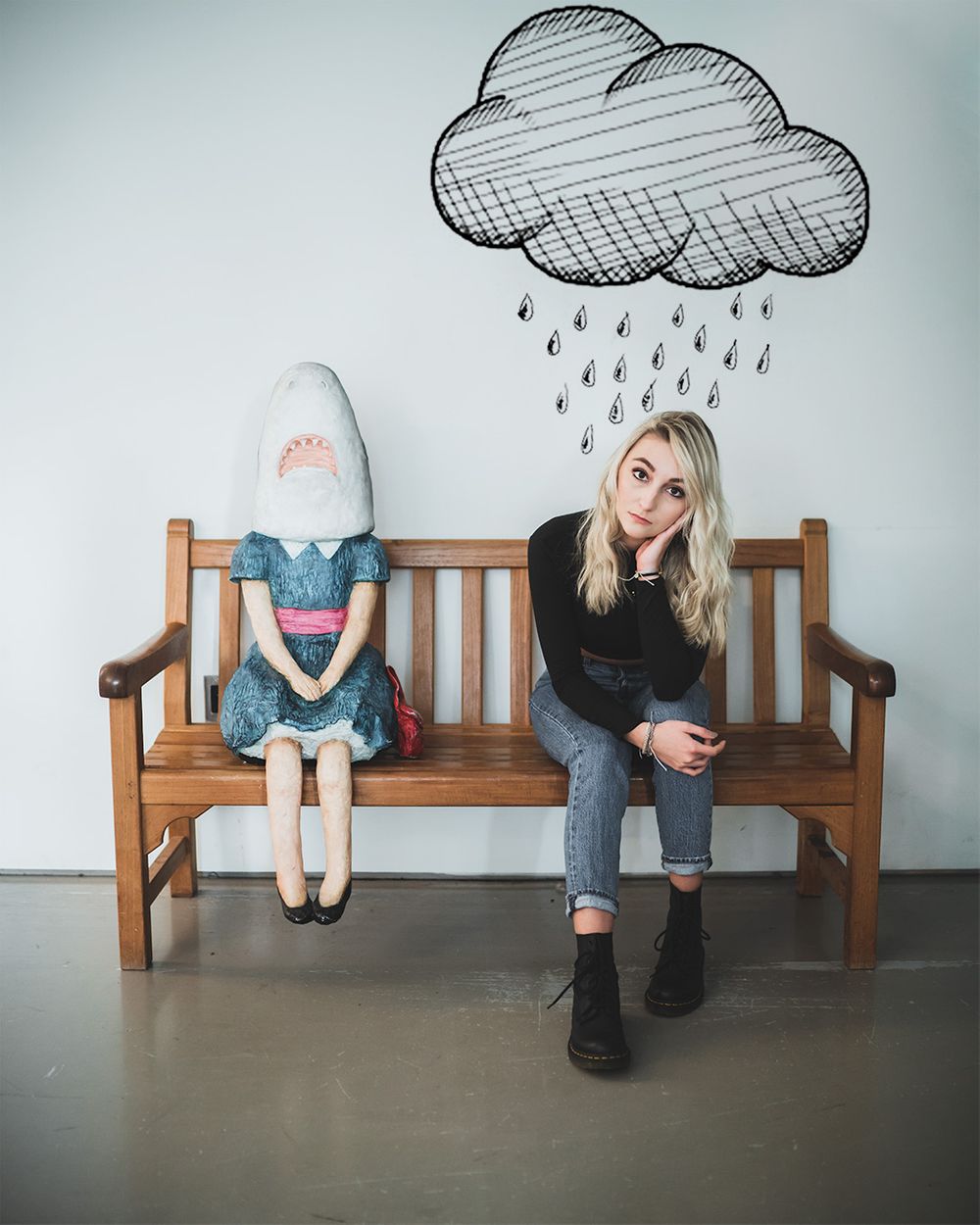 Creative photo with drawn rain cloud above wooden bench featuring artistic composition.