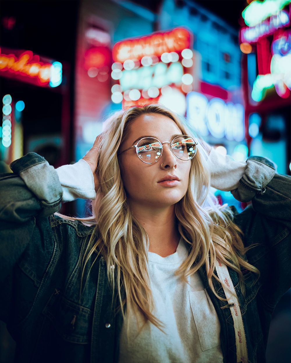 Nighttime portrait with neon lights and urban signage creating a moody city atmosphere.