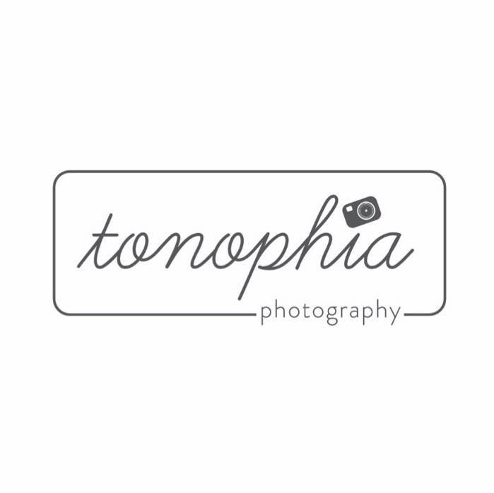 Simple black and white photography business logo design with handwritten text and camera icon.