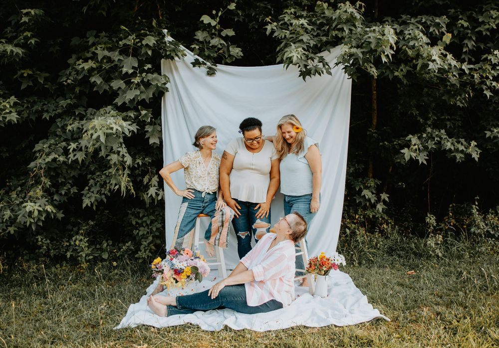 Showing support for breast cancer awareness through pink-themed clothing, ribbons, flowers, and group unity during a photo session